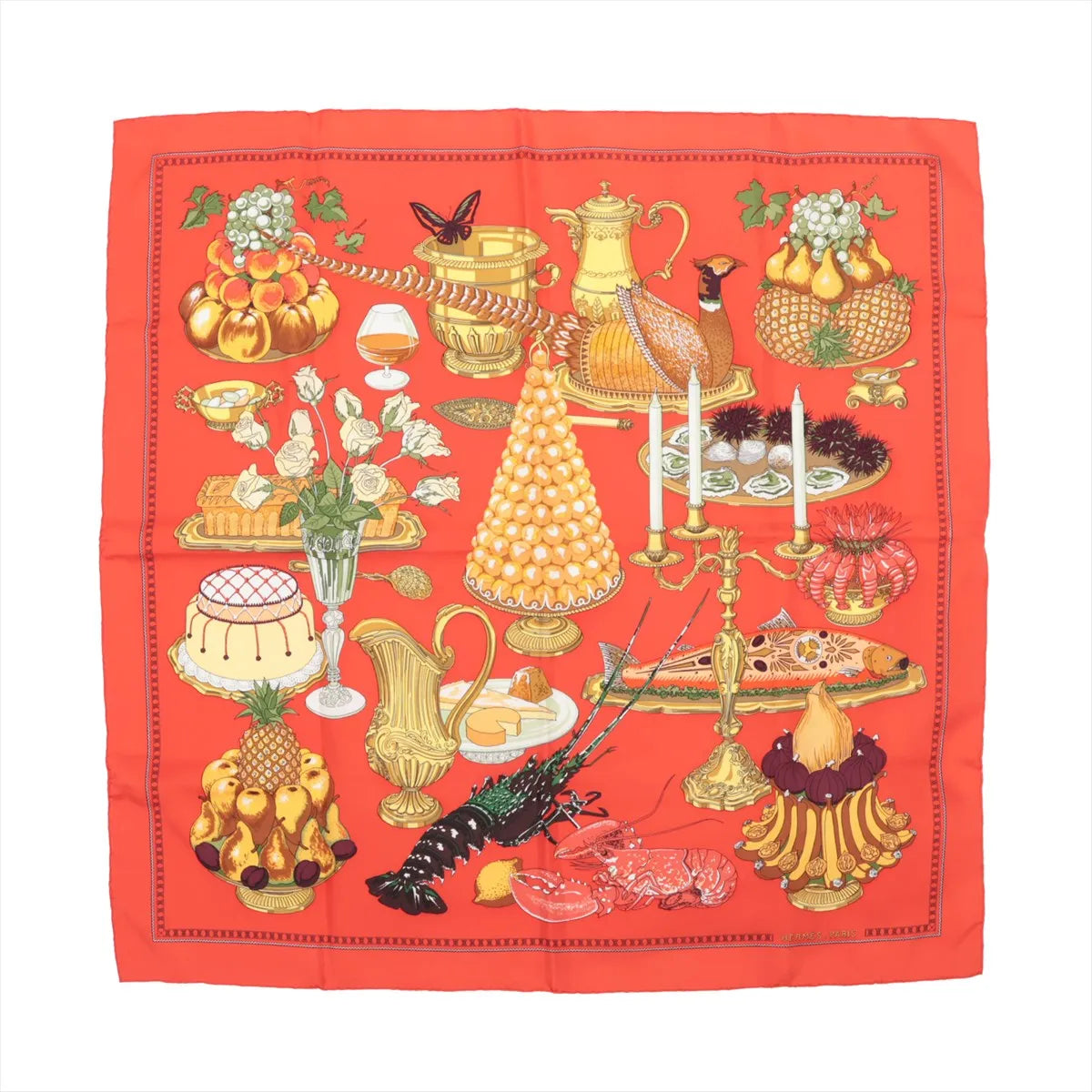 Hermès Carré 90 silk scarf titled "Supper," featuring a detailed and colorful illustration of an elaborate banquet table with desserts, seafood, pastries, fruit arrangements, candlesticks, and golden tableware, all set against a rich red background.