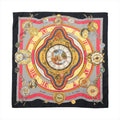 Black Hermès Carré 90 silk scarf laid flat with ornate red, gold, ivory and blue clock and timepiece motifs.