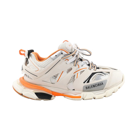 Balenciaga Track sneakers in white and orange with layered mesh and nylon panels, gray detailing, thick rubber sole, and multi-tone laces, displayed on a white background.