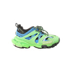 Balenciaga Track sneakers in neon green, blue and black with layered panels, mesh detailing, black-and-green laces, and chunky sole, side view on white background.