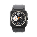 Front view of Bell & Ross BR 03-94 watch with matte black square case, black dial with white markers and large 12 and 6, orange accents, chronograph subdials, date window, and black rubber strap.