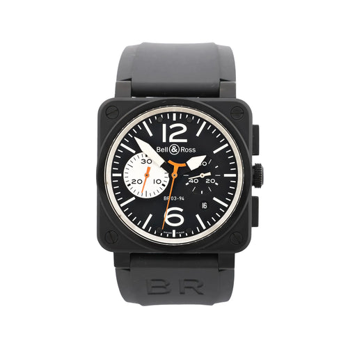 Front view of Bell & Ross BR 03-94 watch with matte black square case, black dial with white markers and large 12 and 6, orange accents, chronograph subdials, date window, and black rubber strap.