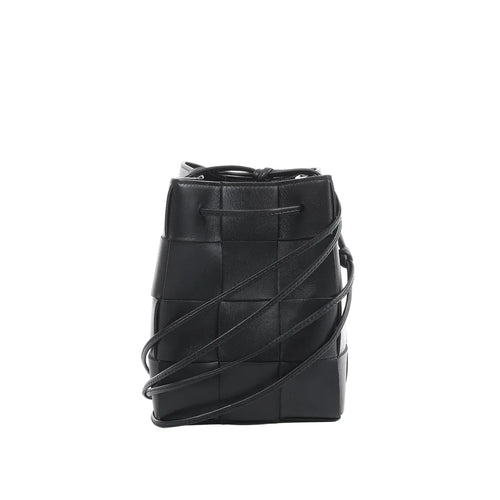 Bottega Veneta Cassette mini bucket bag in black maxi intrecciato woven leather with drawstring top and thin crossbody strap on a white background.