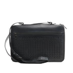 Black Bottega Veneta Intrecciato leather crossbody bag with a woven front panel, top zipper closure, horizontal front zip pocket, and adjustable strap, shown on a white background.