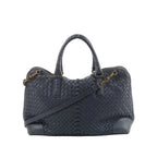 Bottega Veneta navy blue Intrecciato woven leather handbag with top handles, detachable shoulder strap, and gold-tone hardware on white background