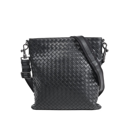 Bottega Veneta VN Nappa Intrecciato crossbody messenger bag in black woven leather with adjustable strap, slim rectangular shape, and minimalist design against a white background.