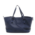 Navy blue Bottega Veneta Intrecciato woven leather shoulder tote bag with two long top handles featuring small buckle details, shown on a white background.