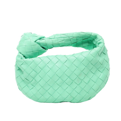 Front view of Bottega Veneta Intrecciato Mini Jodie Leather Handbag in green woven leather with signature top knot handle and rounded shape, displayed against a white background