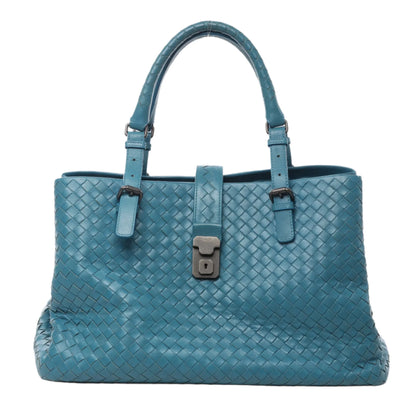 Front view of Bottega Veneta Intrecciato Roma Leather Handbag in blue woven leather with double top handles, adjustable buckle details, and signature lock closure, displayed against a white background.