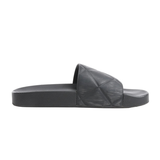 Bottega Veneta Intrecciato Rubber BV Flat Slides in black, size 40 EU, featuring a molded rubber footbed and wide strap with embossed geometric weave pattern, displayed in side profile against a white background.
