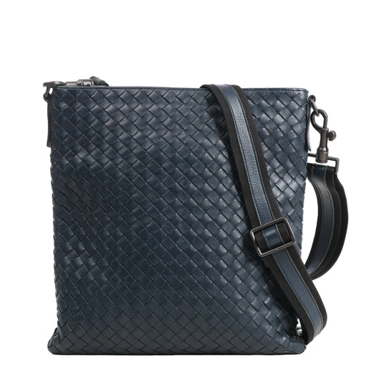 Bottega Veneta VN Intrecciato crossbody messenger bag in navy blue leather featuring the brand’s signature woven pattern, an adjustable shoulder strap with leather and fabric detail, and matte black-tone hardware.