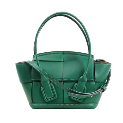 Bottega Veneta Arco Mini 2Way Handbag in green leather, featuring the brand's signature Maxi Intrecciato weave, rounded top handles, adjustable shoulder strap, and structured silhouette, displayed against a white background.