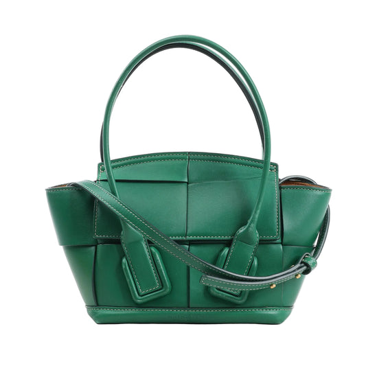 Bottega Veneta Arco Mini 2Way Handbag in green leather, featuring the brand's signature Maxi Intrecciato weave, rounded top handles, adjustable shoulder strap, and structured silhouette, displayed against a white background.