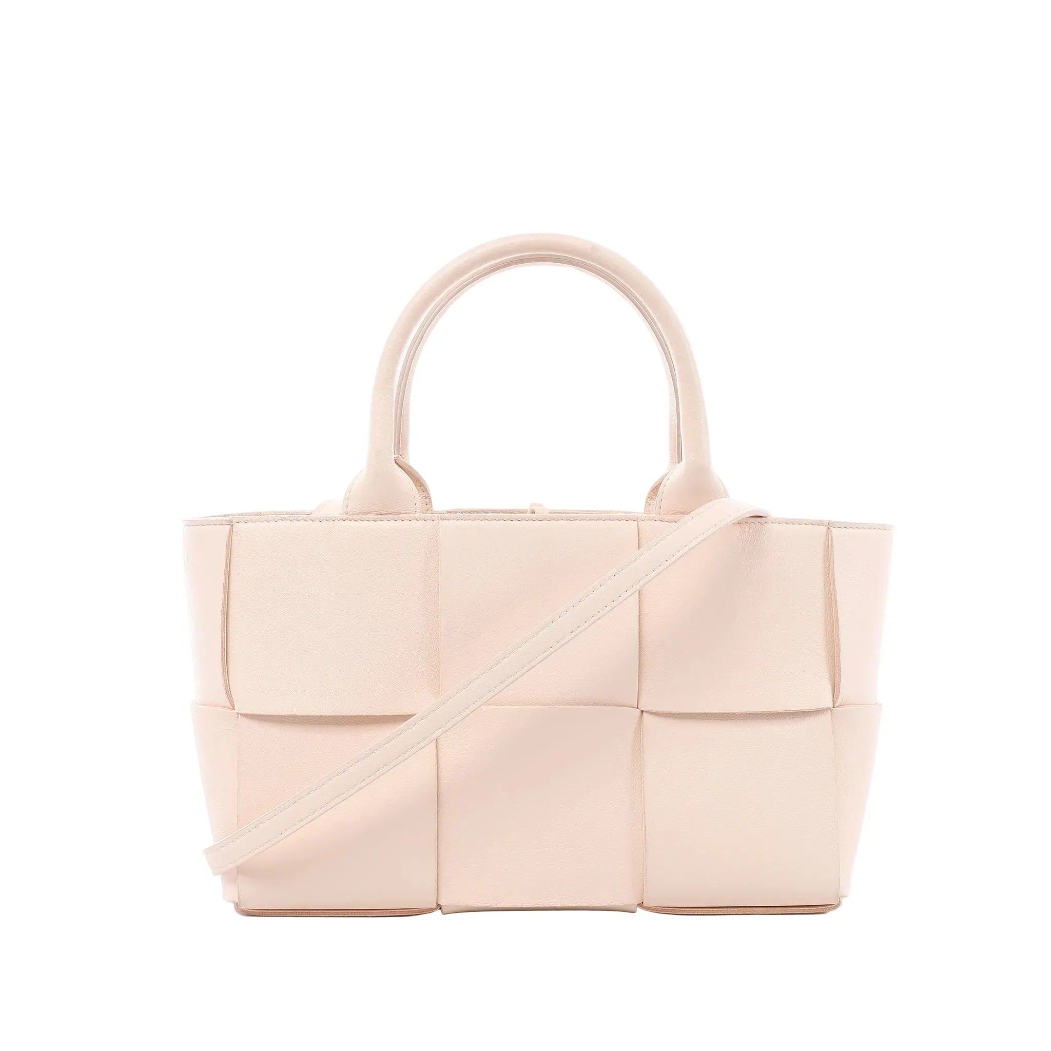 Bottega Veneta Arco handbag in pale pink Maxi Intrecciato woven leather with rounded top handles and slim shoulder strap on white background.