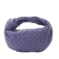 Bottega Veneta Jodie Mini handbag in purple woven Intrecciato leather with a knotted top handle and soft rounded shape.