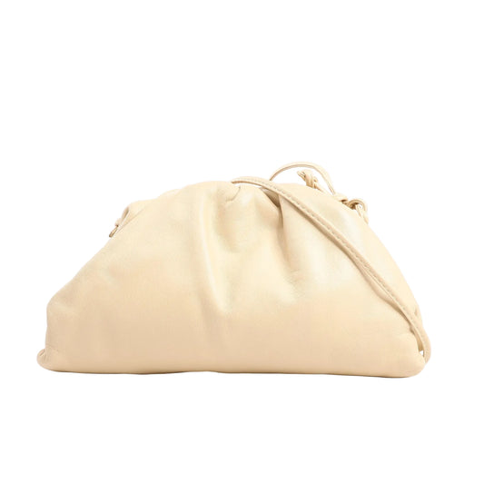 Bottega Veneta Mini The Pouch Crossbody bag in soft beige leather with a slouchy silhouette and thin matching leather strap, displayed on a white background.