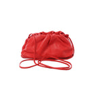 Bottega Veneta Mini The Pouch red leather crossbody bag with gathered ruched top and thin strap on white background
