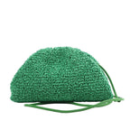 Bottega Veneta The Pouch Mini Crossbody bag in green raffia with a gathered top and slim green leather strap, shown against a white background.