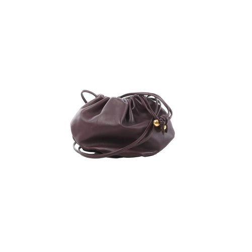 Purple Bottega Veneta mini leather crossbody bag with gathered drawstring top, slim leather strap, and gold-tone bead hardware.