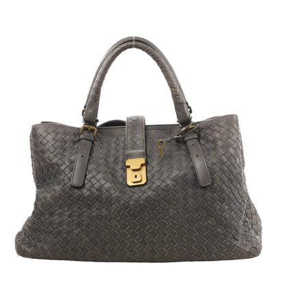 Bottega Veneta Intrecciato Roma handbag in gray woven leather with double top handles, front strap with gold-tone lock, and key charm detail.