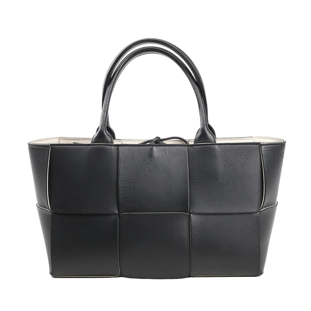 Bottega Veneta The Arco Maxi handbag in black leather with oversized Intrecciato weave, structured silhouette, and double top handles.