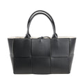 Bottega Veneta The Arco Maxi handbag in black leather with oversized Intrecciato weave, structured silhouette, and double top handles.