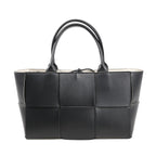 Bottega Veneta The Arco Maxi handbag in black leather with oversized Intrecciato weave, structured silhouette, and double top handles.