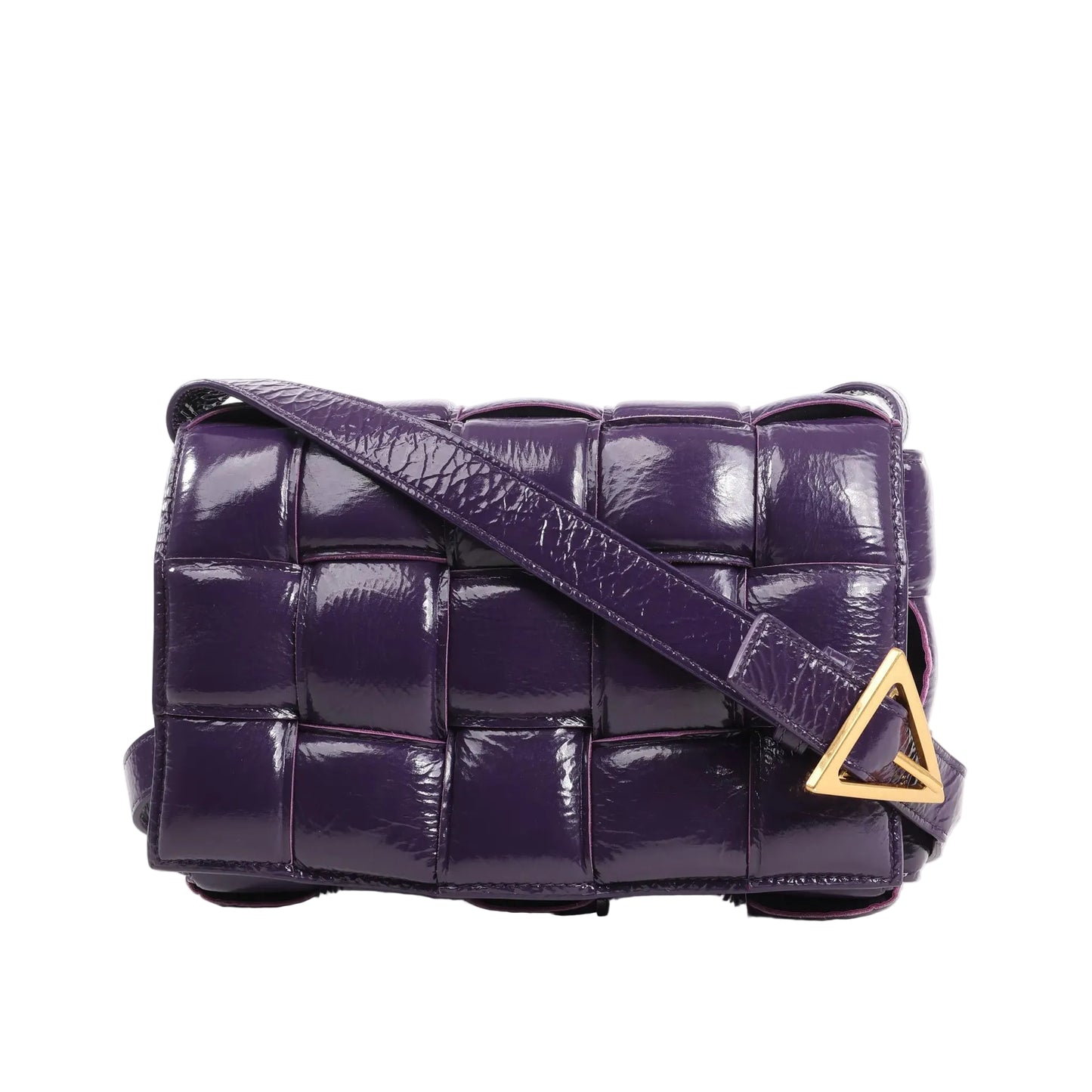 Front view of the Bottega Veneta Padded Cassette Maxi Intrecciato shoulder bag in glossy purple patent leather, featuring large woven panels, a matching strap, and a gold-tone triangle buckle.