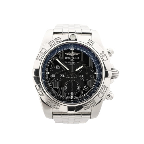 Close-up of Breitling Chronomat stainless steel watch with black Roman-numeral dial, three chronograph subdials, tachymeter ring, engraved bezel and date window.