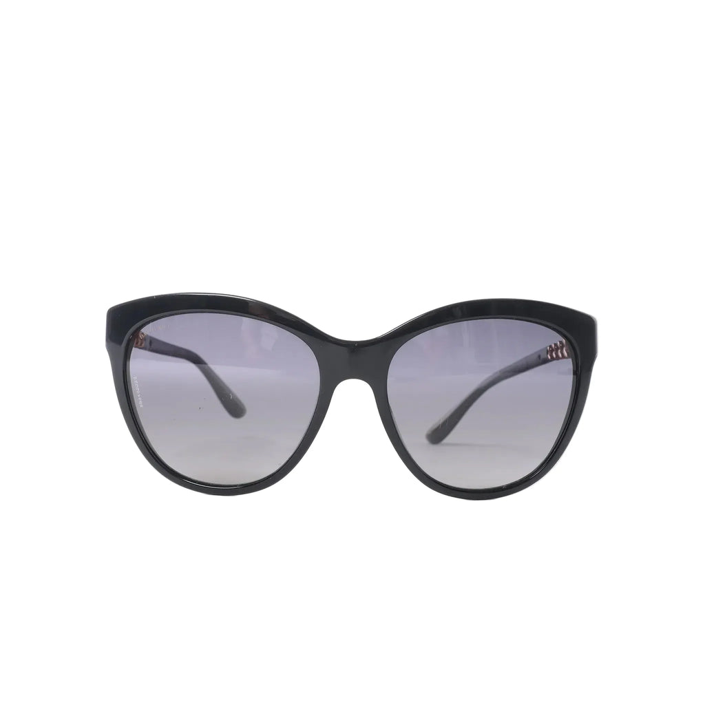 Bvlgari BV8158 black cat-eye sunglasses with gray tinted lenses, glossy frame, slim curved temples and subtle gold-tone branding on white background.