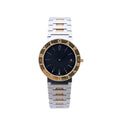 Bvlgari Bvlgari BB33SGD watch with black dial, gold-tone logo bezel, stainless steel and yellow gold bracelet, date window, and round case on white background.