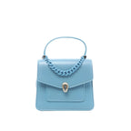 BVLGARI Serpenti Forever handbag in light blue leather with top handle, blue chain detail, flap front pocket, and silver Serpenti snakehead clasp, front view on white background.