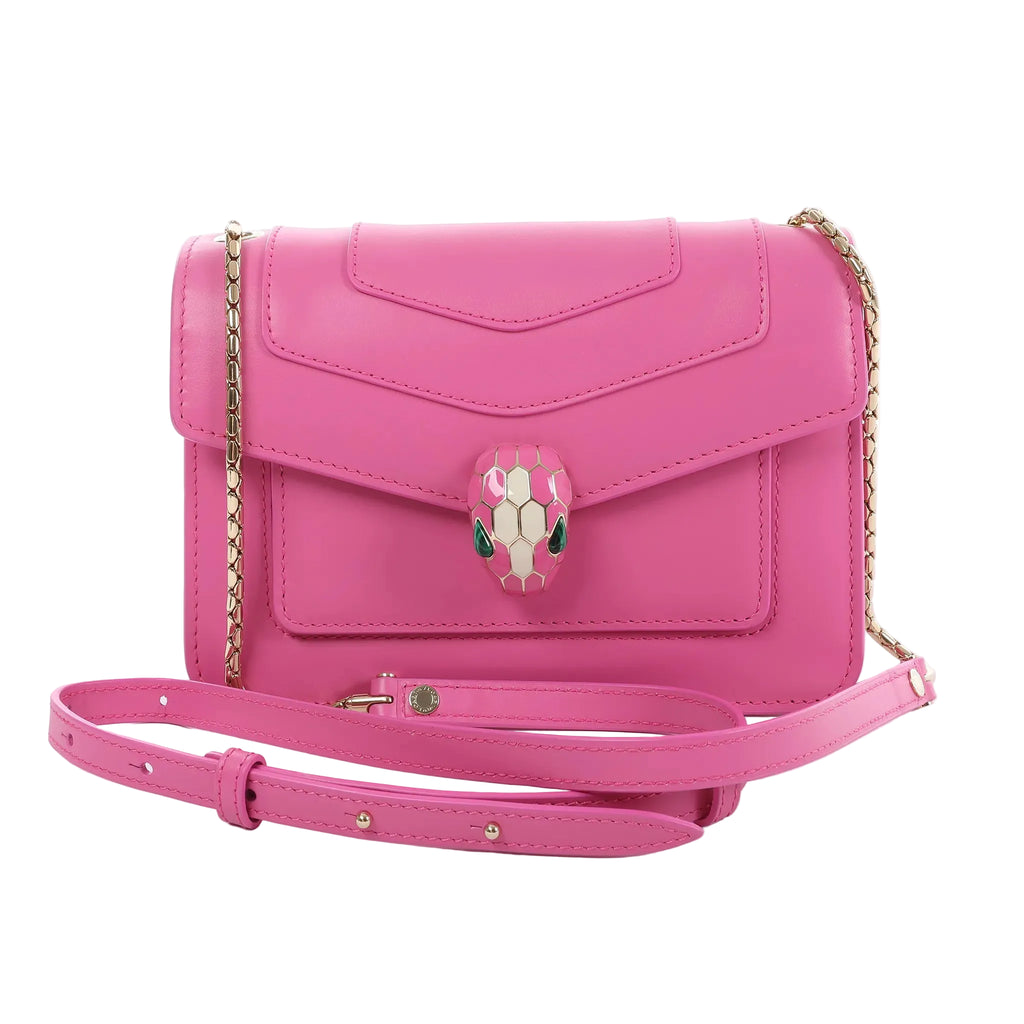 BVLGARI Serpenti Forever pink leather crossbody bag with flap front, enamel snakehead clasp, gold-tone chain strap, and detachable adjustable leather strap on a white background.