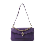 Bvlgari Serpenti purple leather shoulder bag with gold-tone chain detail and snake head clasp, shown with long adjustable strap on white background.