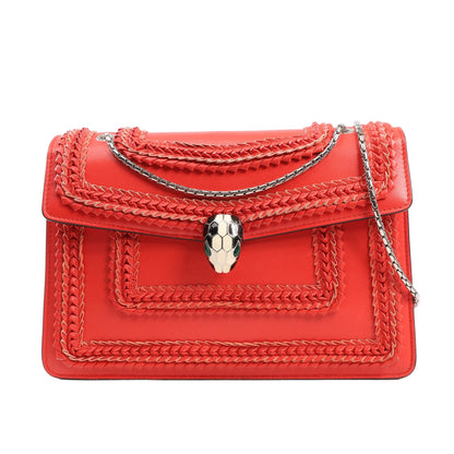 BVLGARI Serpenti Forever red patent leather shoulder bag with braided detailing, silver chain strap, and signature white and black snakehead clasp.