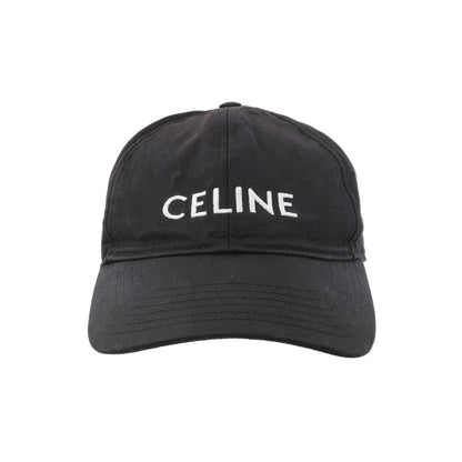 CELINE black cotton baseball cap with white embroidered CELINE logo on the front and a curved brim, shown from the front against a white background.