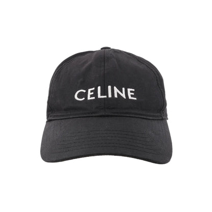 CELINE black cotton baseball cap with white embroidered CELINE logo on the front and a curved brim, shown from the front against a white background.