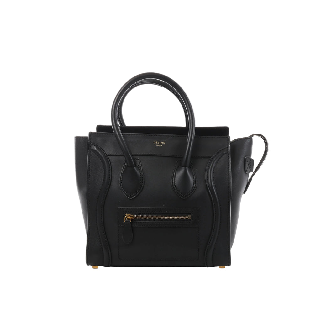 Black Celine Luggage Micro leather handbag with structured top handles, winged sides, front zip pocket and gold-tone logo detailing.