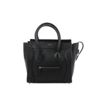 Black Celine Luggage Micro leather handbag with structured top handles, winged sides, front zip pocket and gold-tone logo detailing.