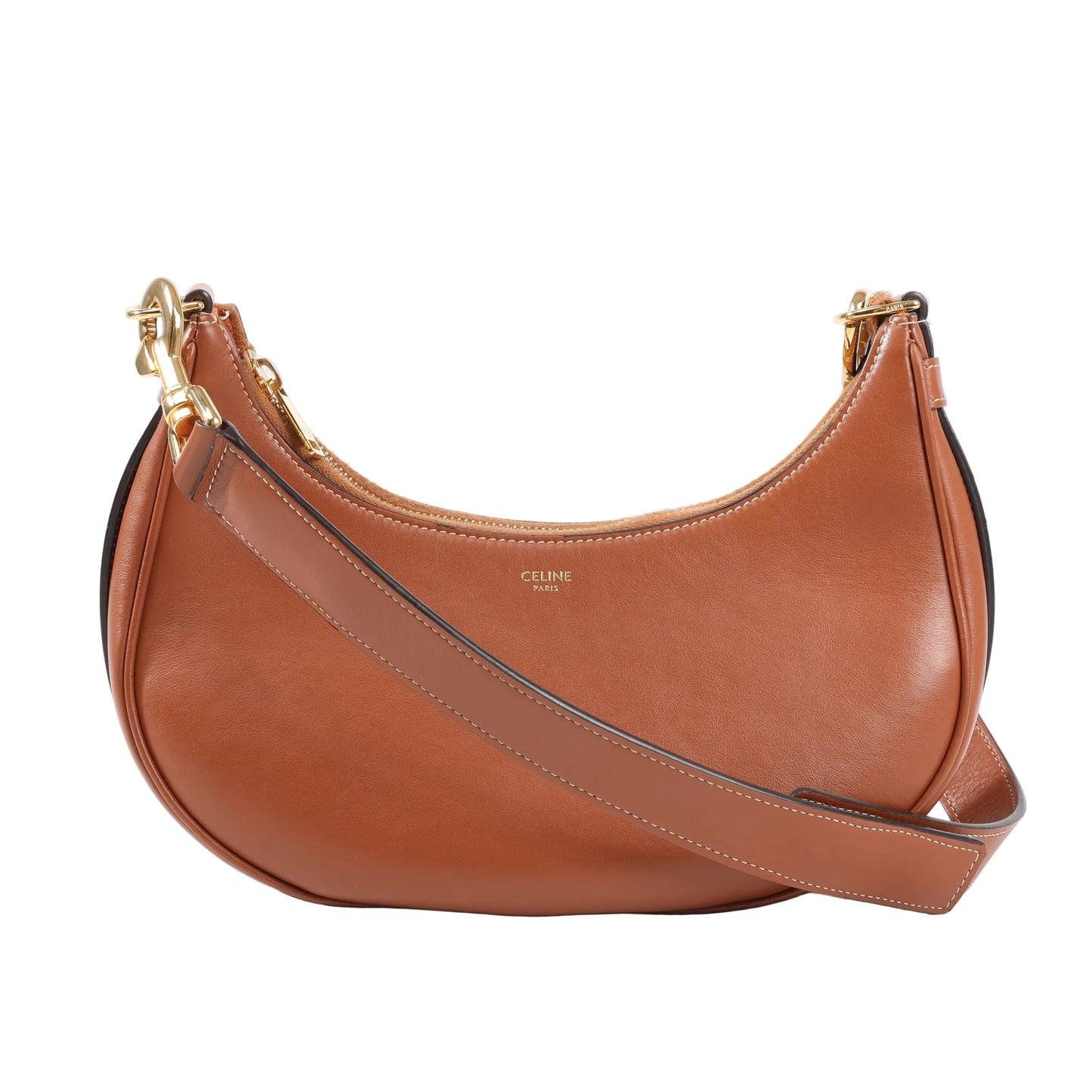 Front view of CELINE Ava Shoulder Bag in smooth brown leather, featuring a curved crescent shape, wide adjustable strap with stitching, gold-tone hardware, and discreet CELINE Paris logo at the center.
