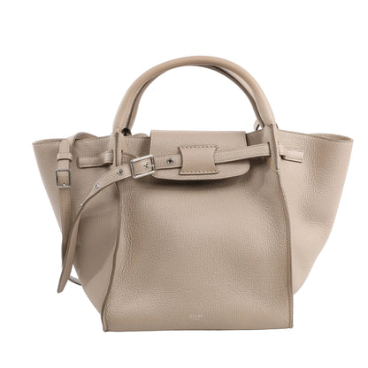 CELINE Big Bag Small 2way Handbag in greige grained leather with top handles, adjustable shoulder strap, belt closure, and winged sides, displayed upright against a white background.