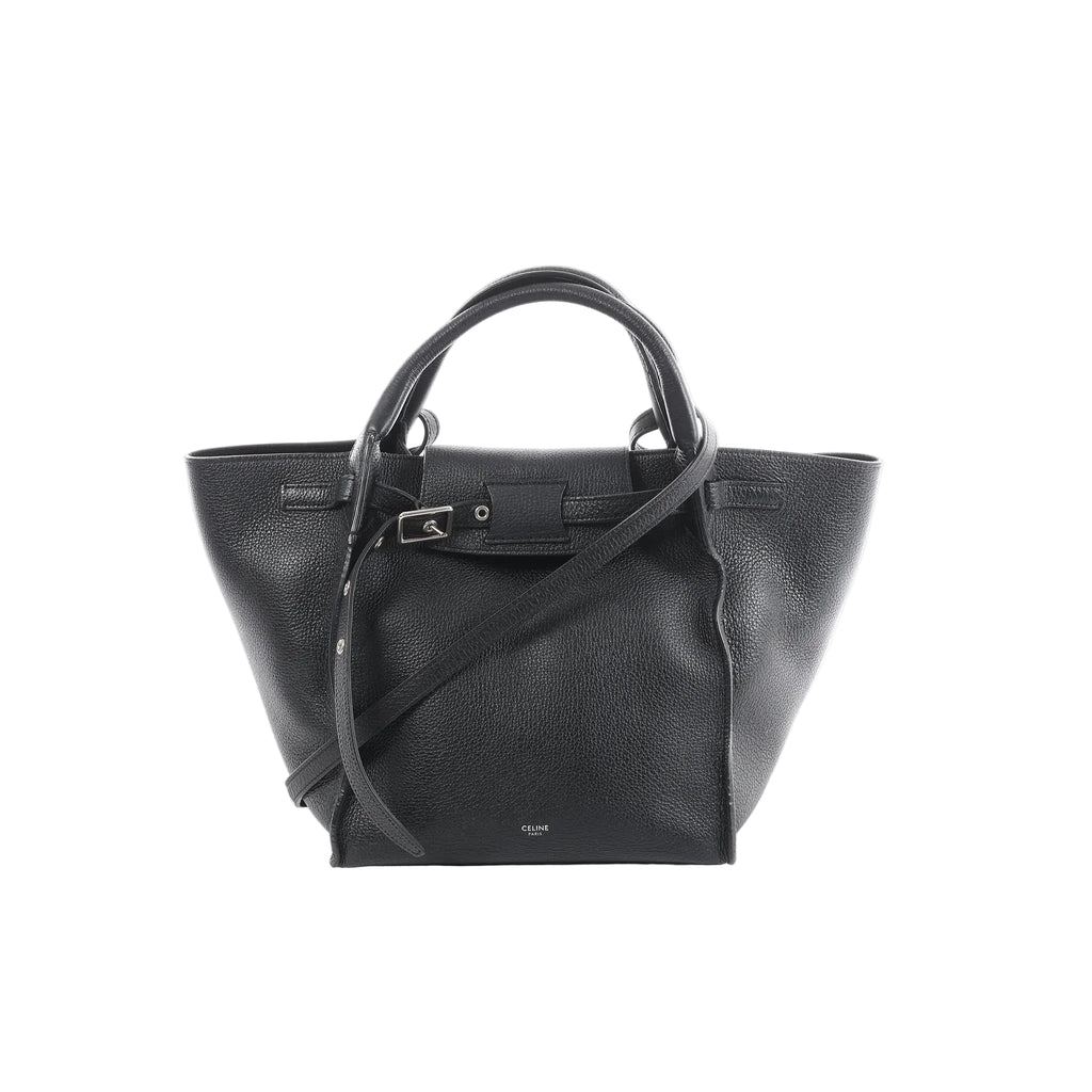 Céline Big Bag Small black grained leather tote with top handles, long shoulder strap, and front buckle strap detail, front view on white background.