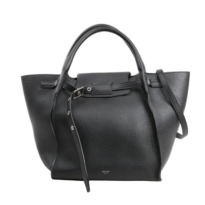 CELINE Big Bag Small 2-way handbag in black grained leather featuring top handles, a long shoulder strap, a front leather belt buckle closure, and silver-tone hardware.