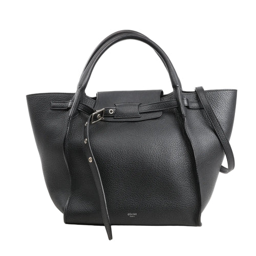 Black CELINE Big Bag Small grained leather handbag with top handles, belted strap detail, and shoulder strap on white background