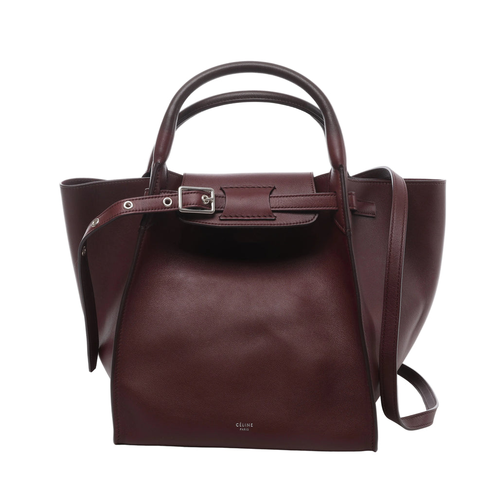 Burgundy Celine Big Bag Small leather handbag with rounded top handles, long shoulder strap, belted front closure and silver-tone buckle hardware.