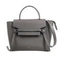 CELINE Belt Bag Micro in gray grained calfskin leather with top handle, flap front, knotted belt detail, and detachable shoulder strap, displayed against a white background.