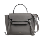 CELINE Belt Bag Micro in gray grained calfskin leather with top handle, flap front, knotted belt detail, and detachable shoulder strap, displayed against a white background.