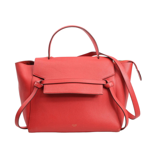 Celine Belt Bag Mini in red grained leather with a structured top handle, front flap with signature knotted belt design, and detachable shoulder strap, set against a white background.
