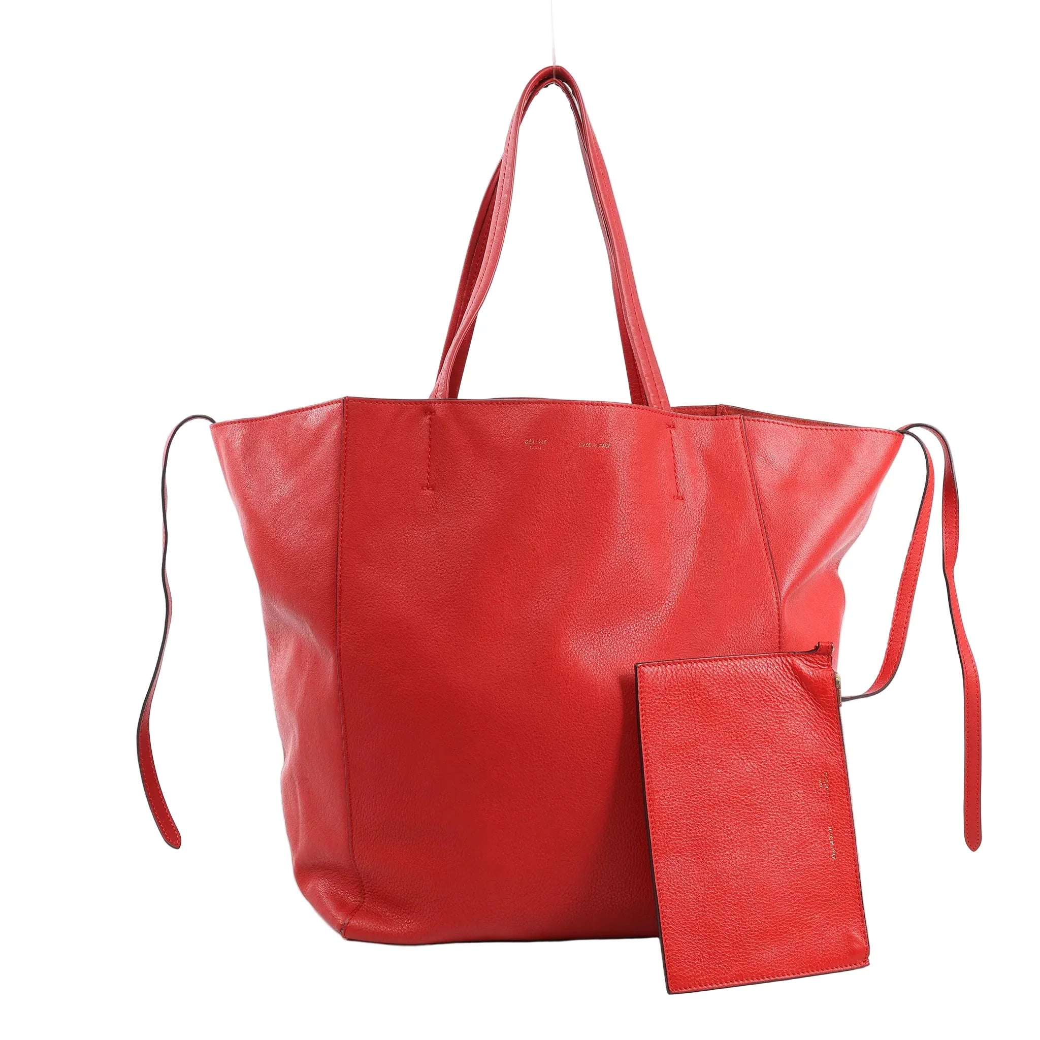 Celine Cabas Phantom Large Shoulder Bag in red grained leather with double top handles, side leather tie accents, and matching zip pouch, displayed upright against a white background.