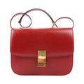 CELINE Classic Box Medium shoulder bag in smooth red calfskin leather with structured flap design, adjustable strap, and gold-tone push-lock closure.